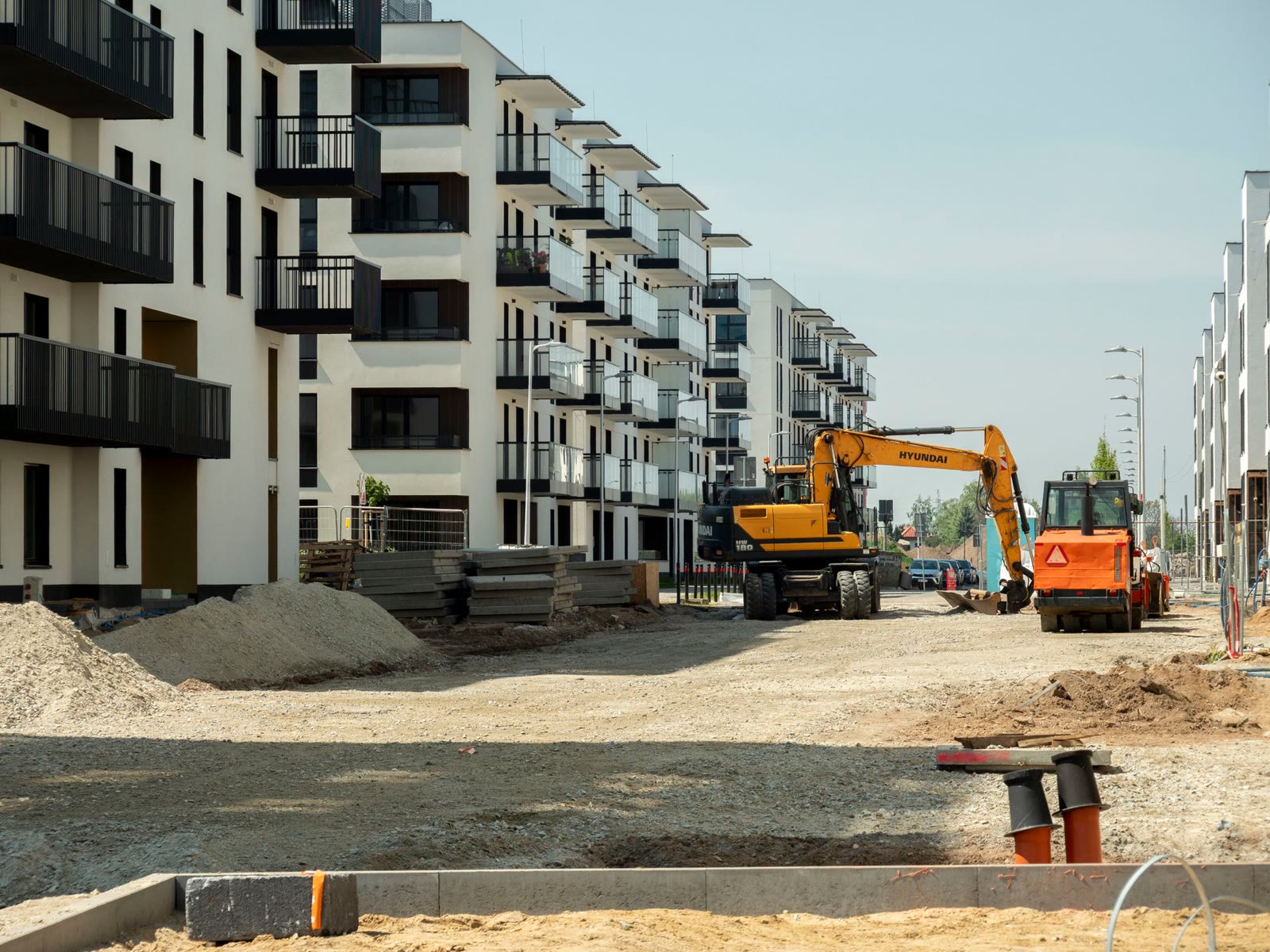 Finished apartment buildings with excavators still on site