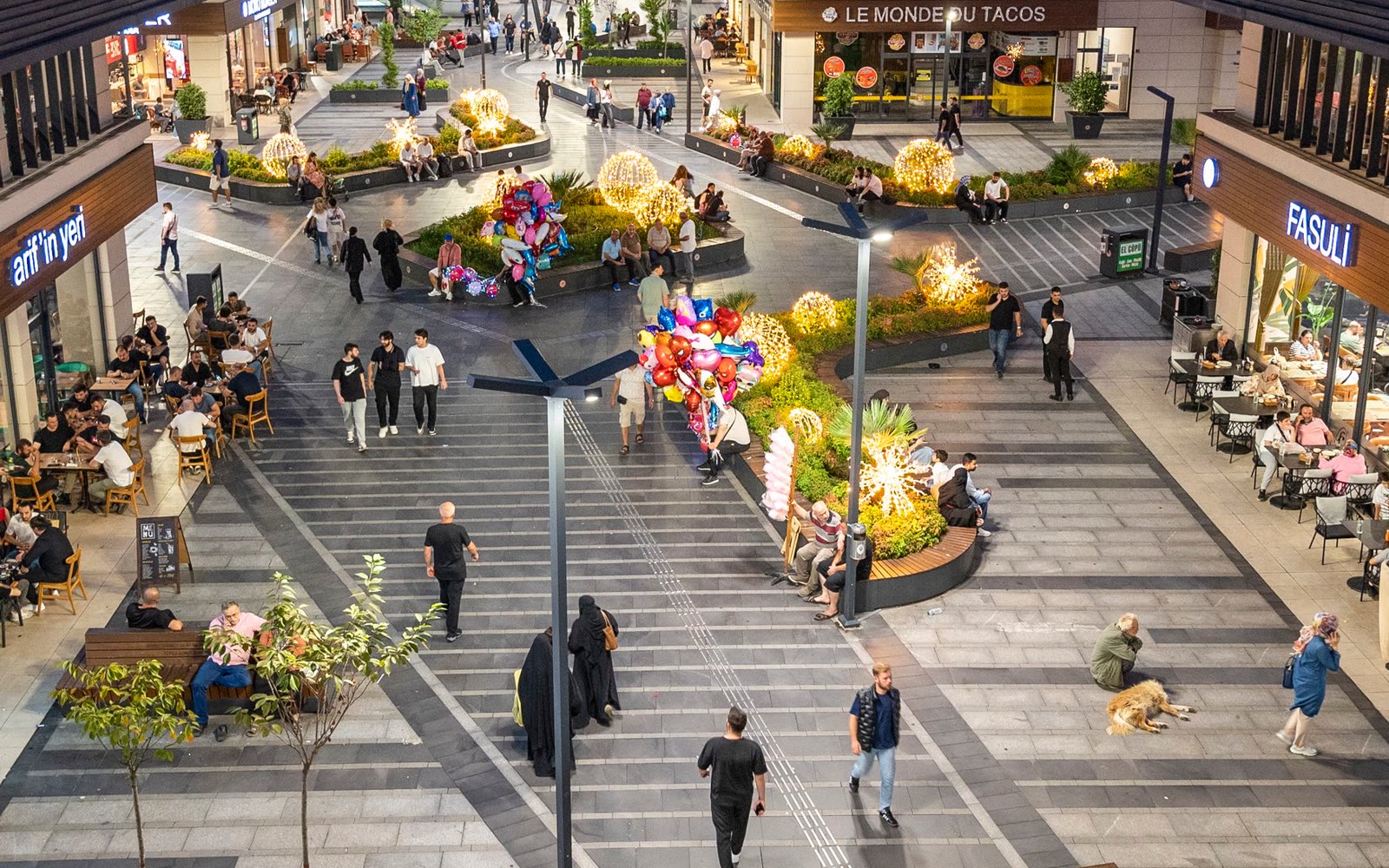 Landscaped retail plaza busy with shoppers and diners
